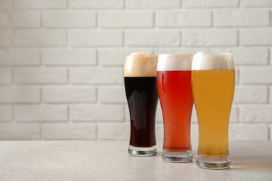 Photo of Glasses with different types of cold tasty beer on table