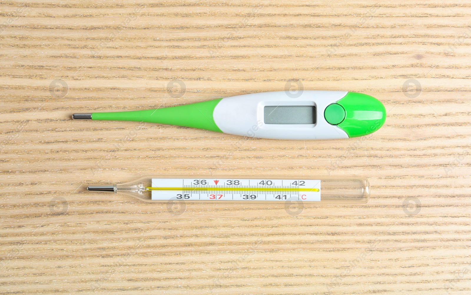 Photo of Modern digital and mercury thermometers on wooden table, flat lay