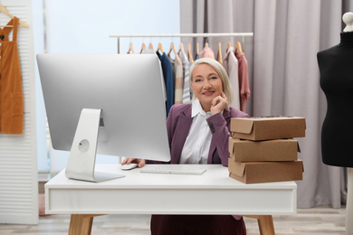 Female business owner working with computer in boutique