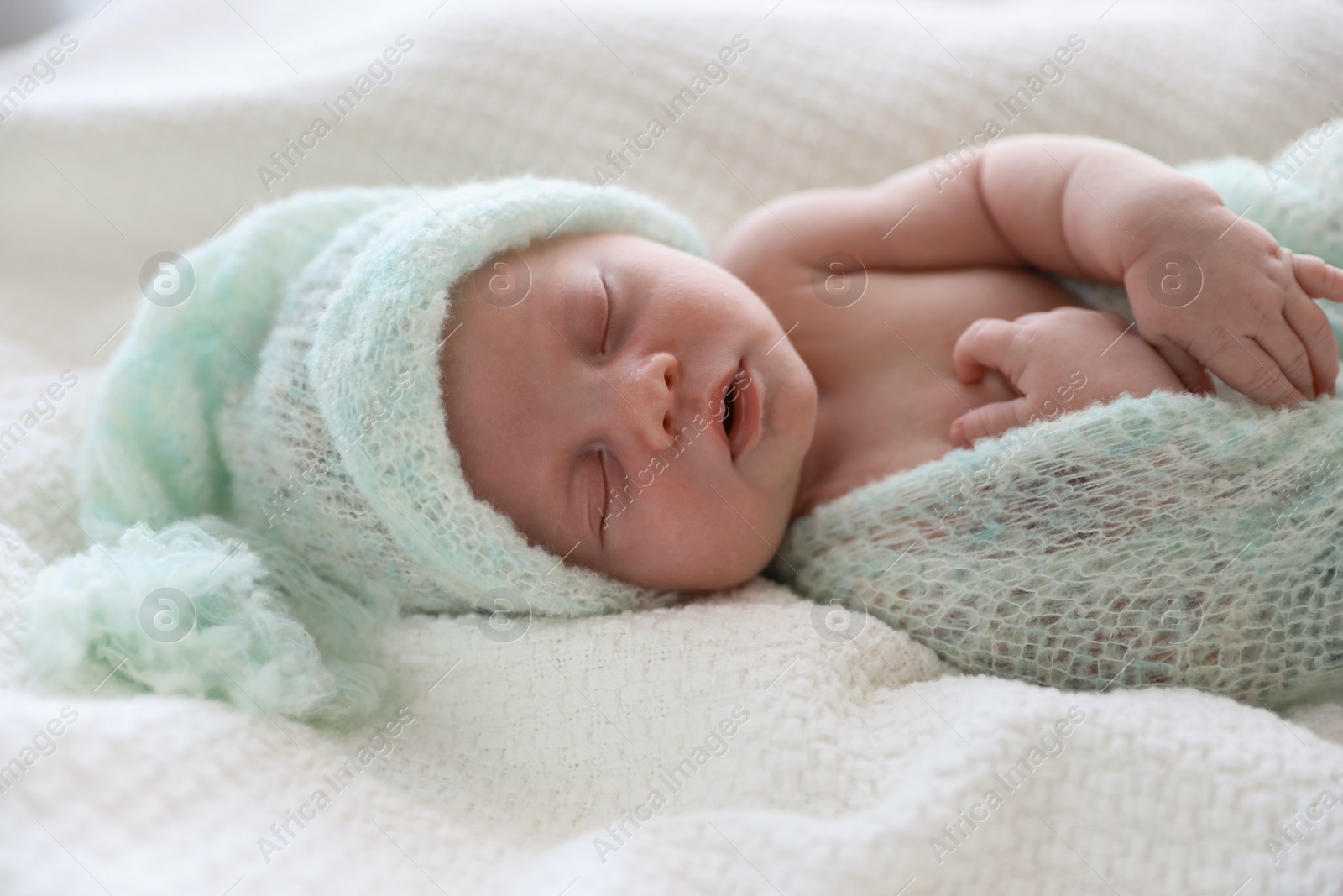 Photo of Cute newborn baby in warm hat sleeping on white plaid