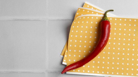 Photo of Pepper plasters and chili on white tiled table, top view. Space for text