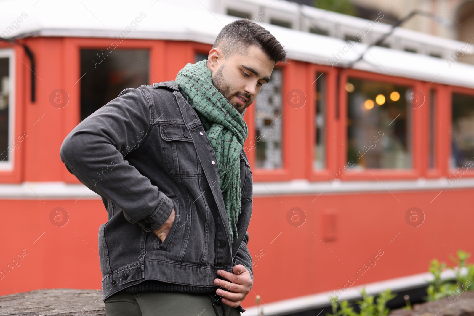 Photo of Handsome man in warm scarf outdoors. Space for text