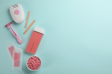Photo of Set of epilation tools and products on turquoise background, flat lay. Space for text