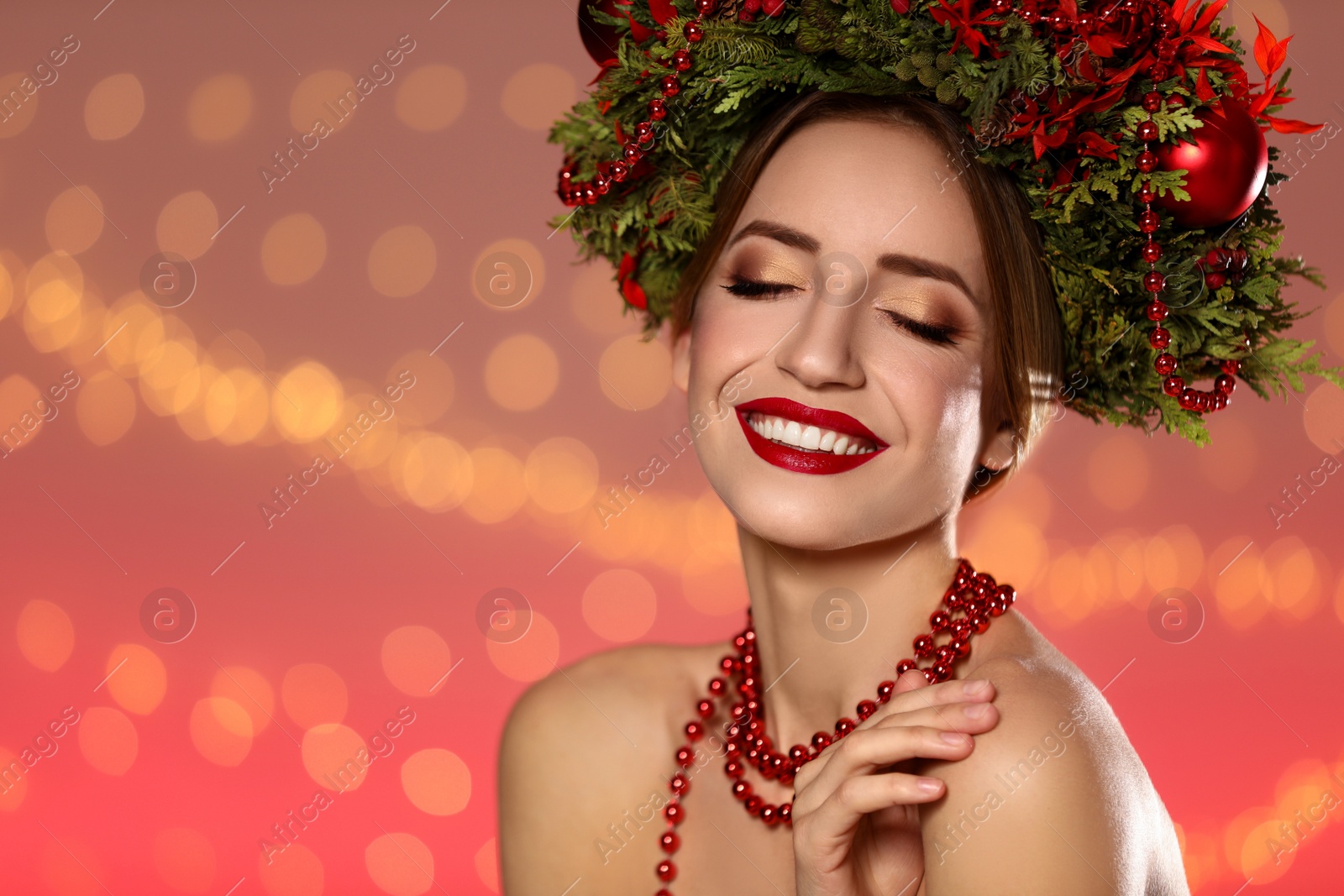 Photo of Beautiful young woman wearing Christmas wreath against blurred festive lights. Space for text