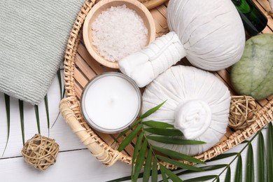 Flat lay composition with candle and different spa products on white wooden table