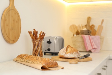 Photo of Loaves of bread and grissini on counter in kitchen