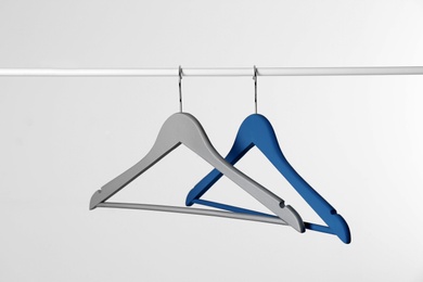 Photo of Metal rack with clothes hangers on white background