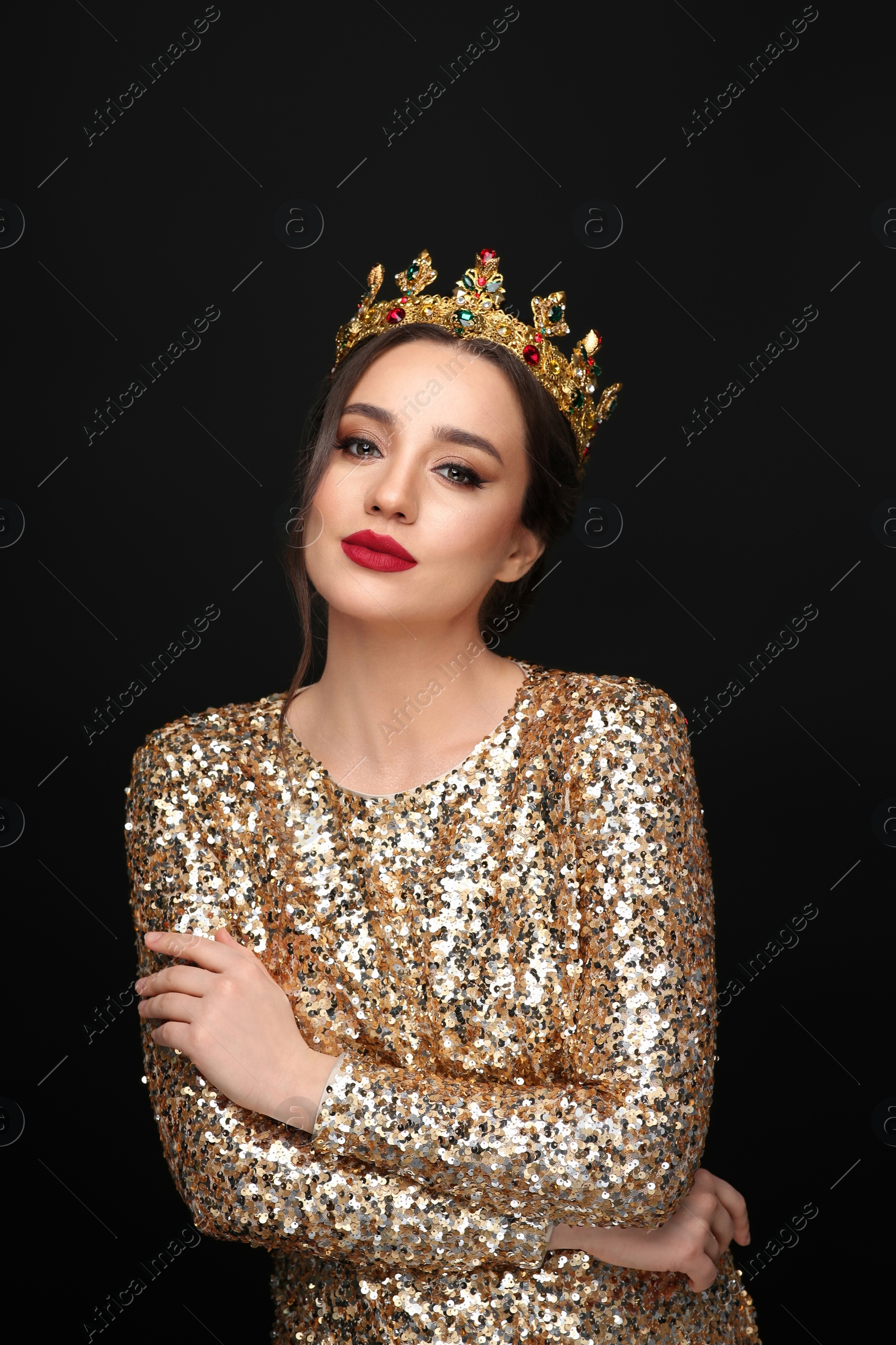 Photo of Beautiful young woman wearing luxurious crown on black background