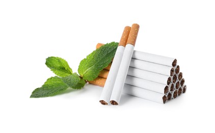 Photo of Menthol cigarettes and fresh mint leaves on white background