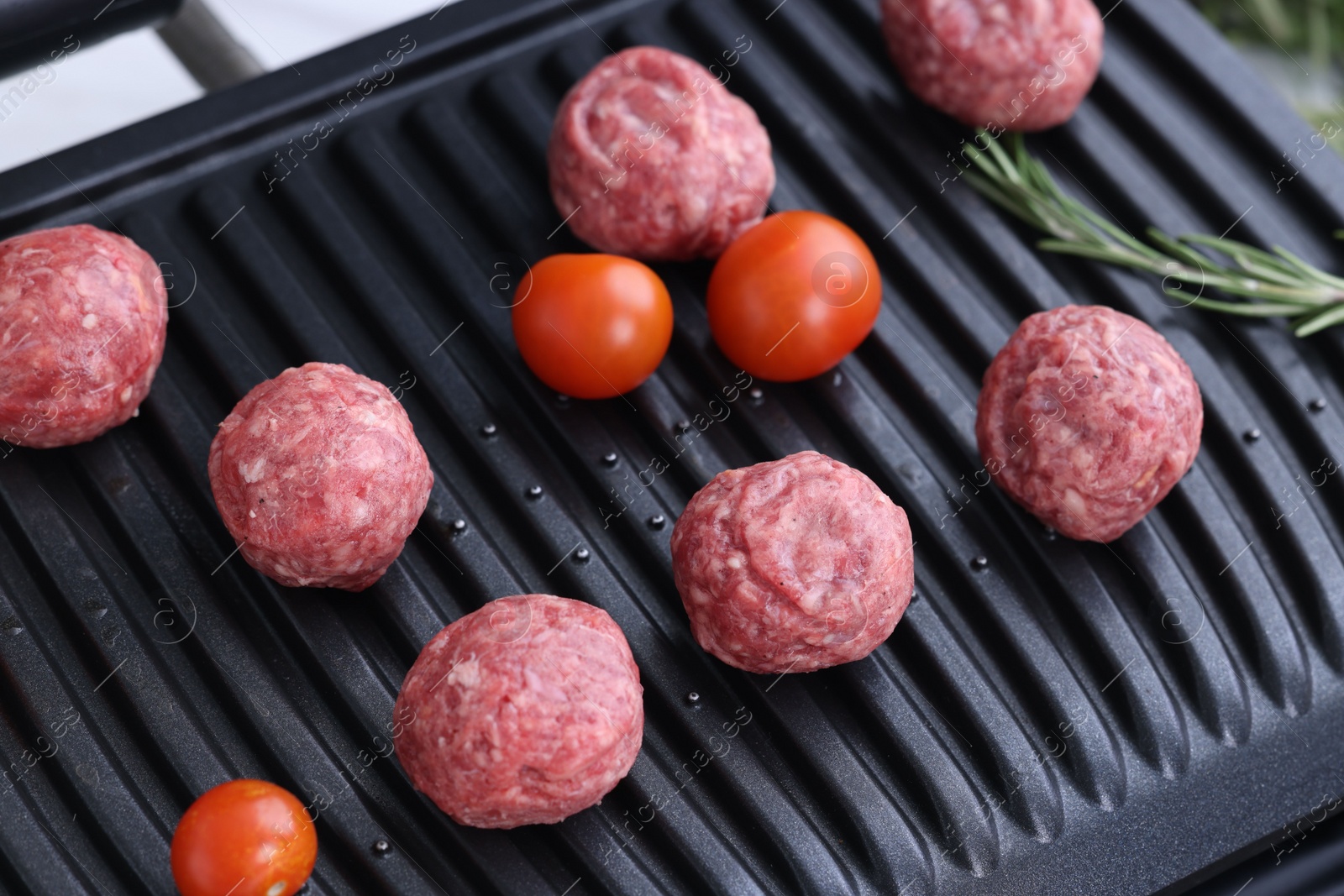 Photo of Meatballs and tomatoes on electric grill, closeup