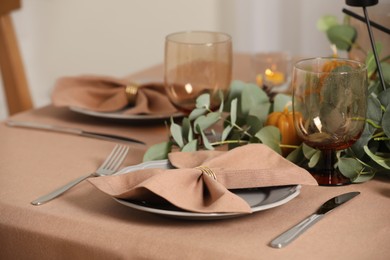 Photo of Autumn table setting with eucalyptus branches indoors