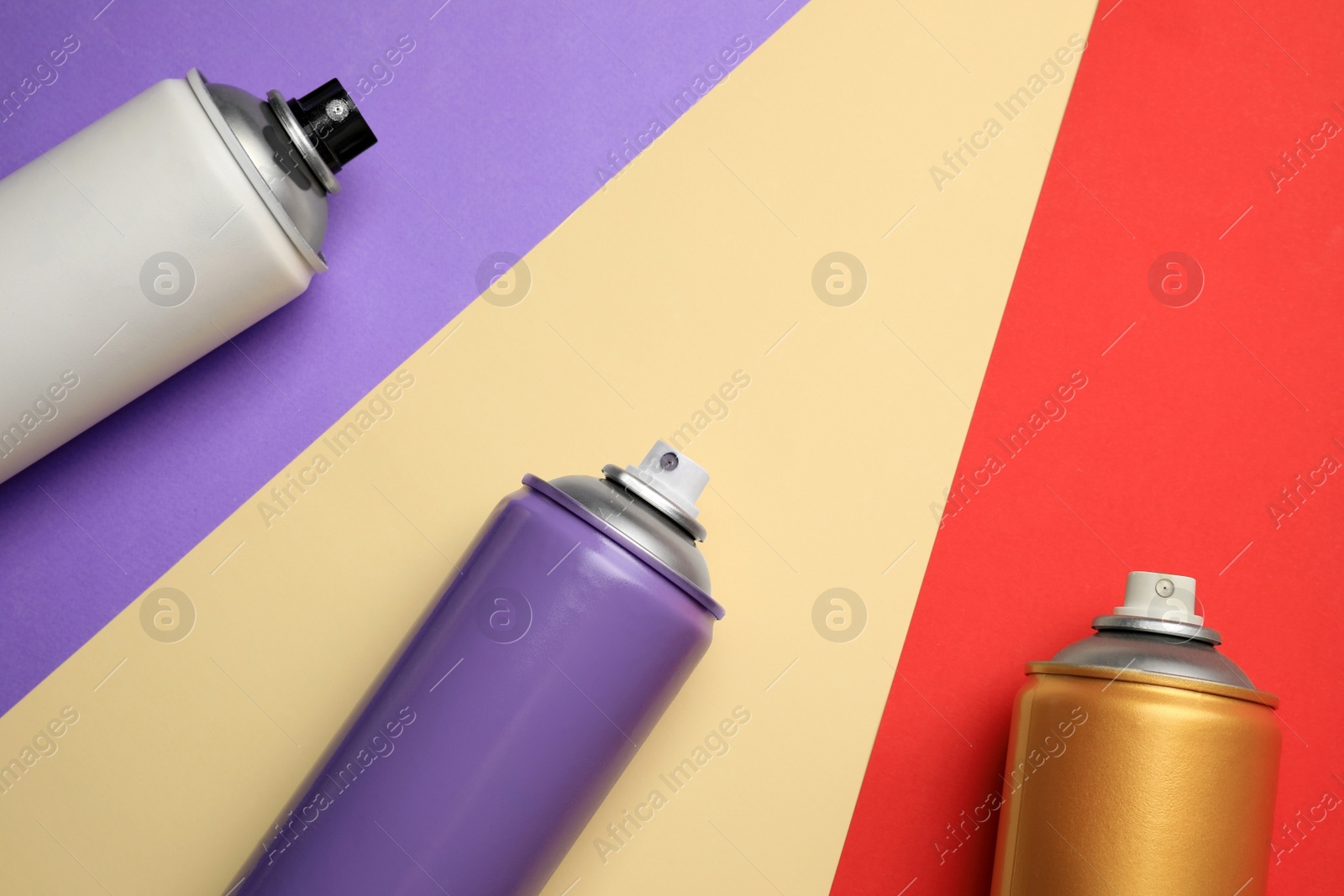Photo of Cans of different spray paints on color background, flat lay with space for text. Graffiti supplies