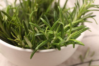 Photo of Bowl with fresh green rosemary on table, closeup