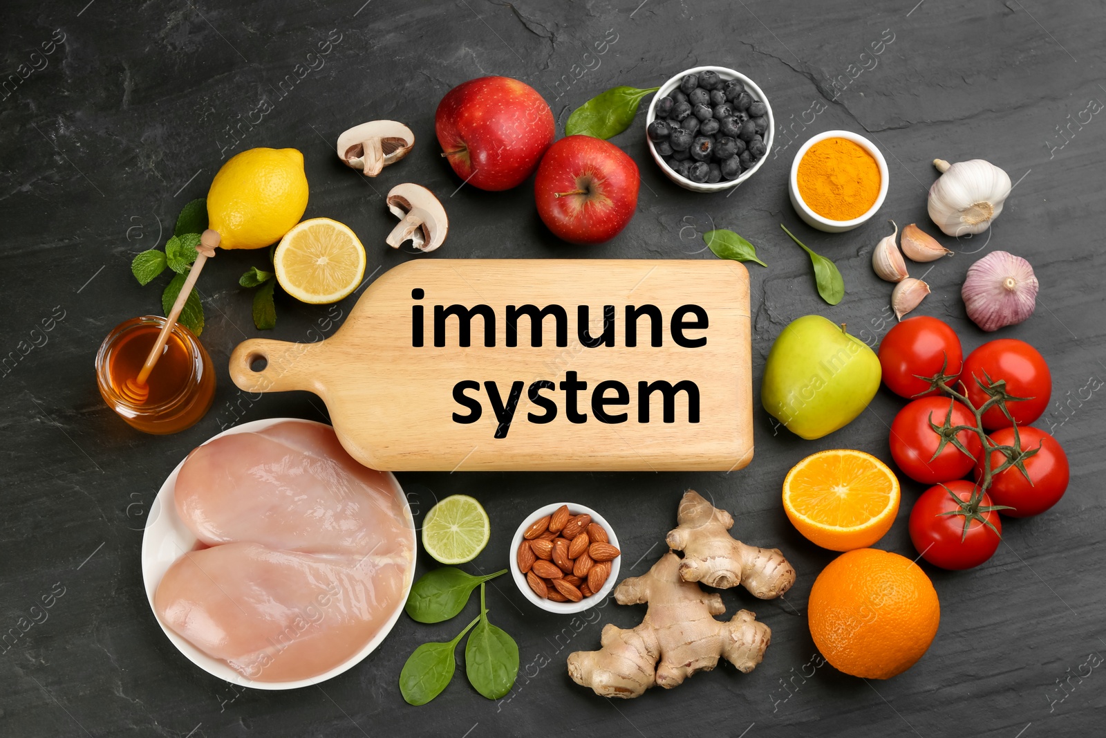 Photo of Wooden board with phrase Immune System and fresh products on dark grey background, flat lay
