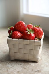 Photo of Fresh juicy strawberries in wicker basket on windowsill, closeup