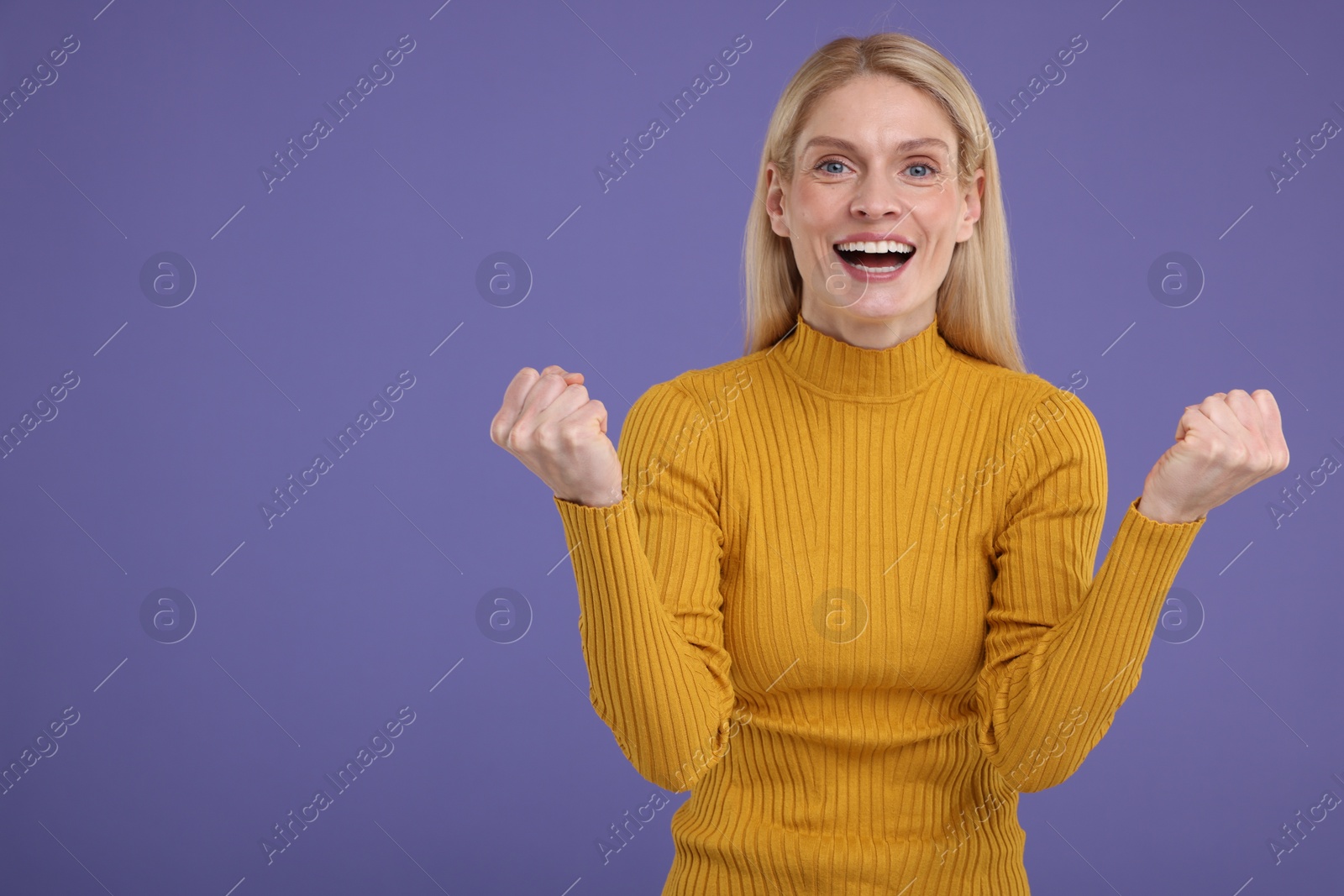 Photo of Portrait of happy surprised woman on violet background, space for text