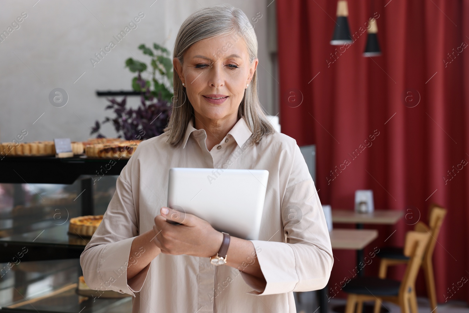 Photo of Business owner using tablet in her cafe