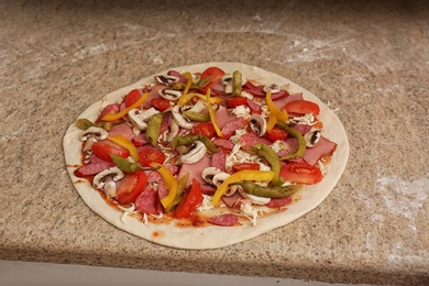 Photo of Uncooked pizza with different toppings on table. Oven recipe