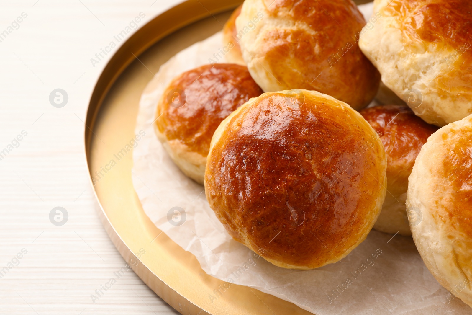 Photo of Plate with freshly baked soda water scones on white wooden table, closeup