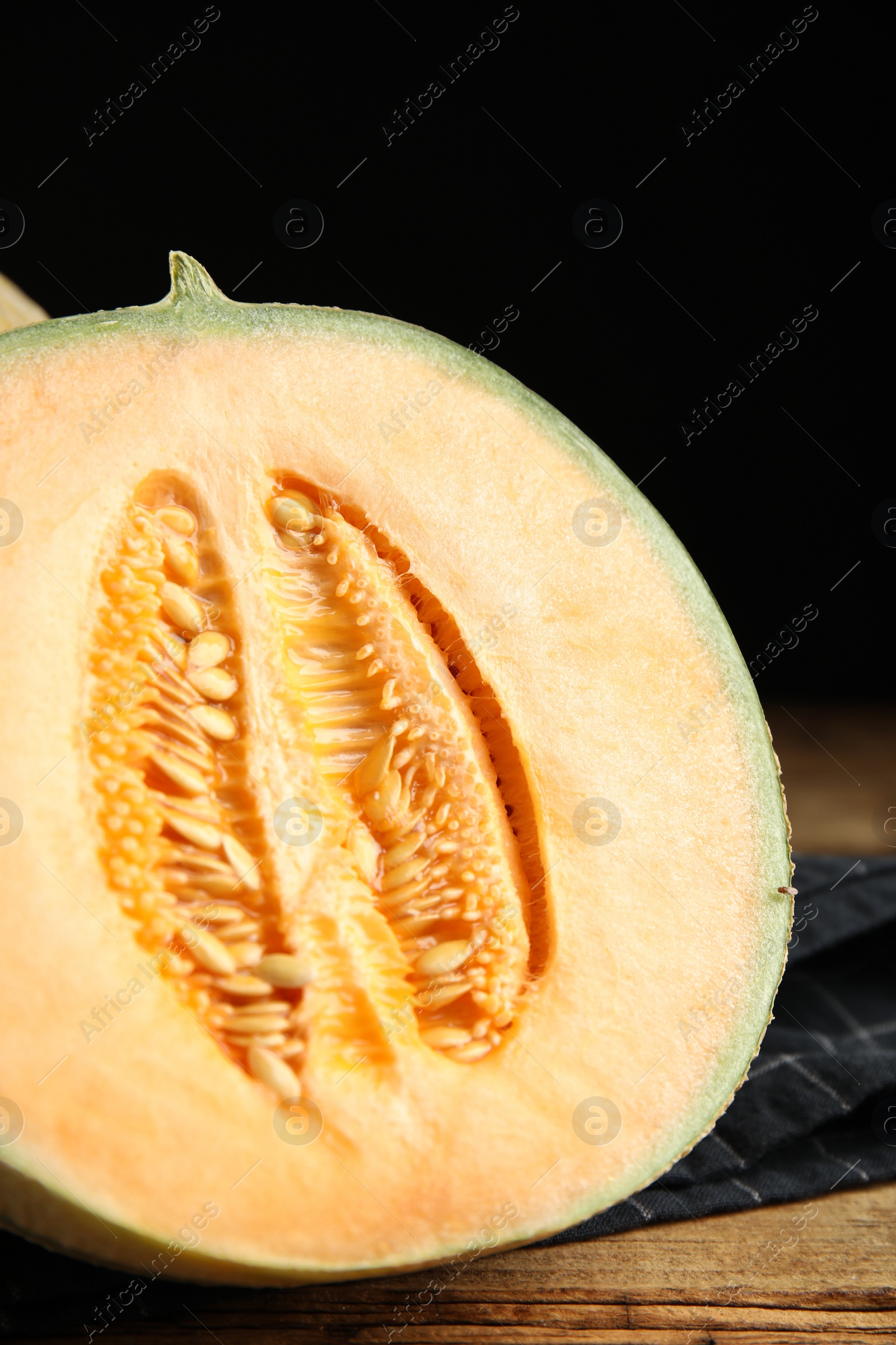 Photo of Half of fresh melon on wooden table, closeup