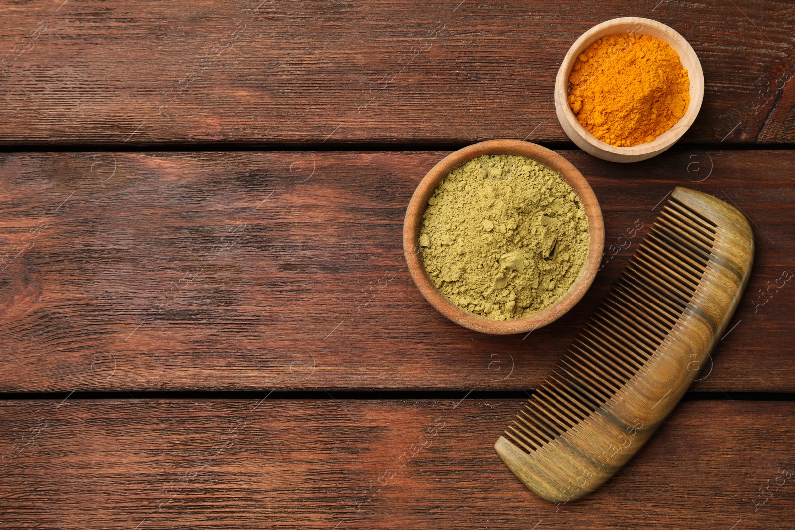 Photo of Comb, henna and turmeric powder on wooden table, flat lay. Space for text