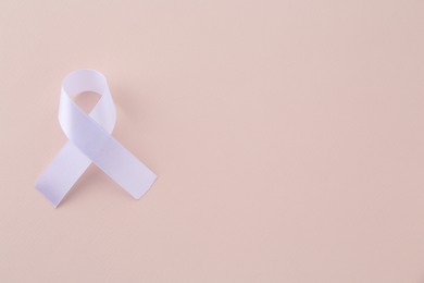 Photo of White awareness ribbon on beige background, top view. Space for text