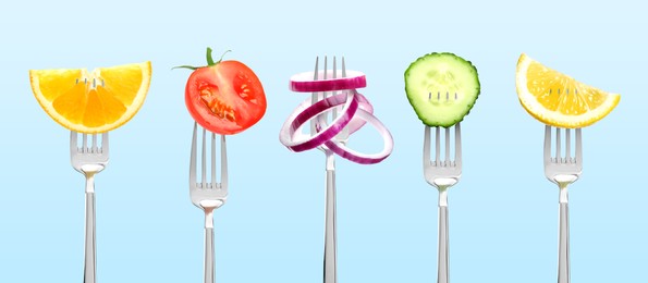 Image of Forks with different food products on light blue background, collection