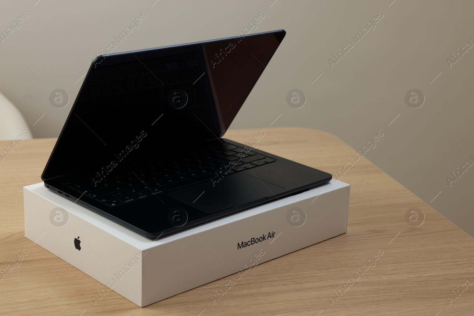 Photo of Leiden, Netherlands - October 6, 2023: Modern black MacBook Air and box on wooden table