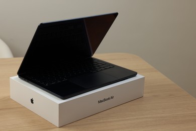 Leiden, Netherlands - October 6, 2023: Modern black MacBook Air and box on wooden table