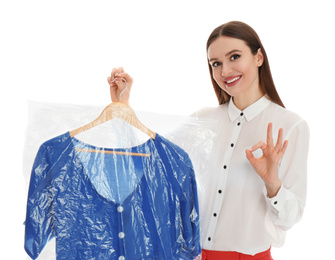 Young woman holding hanger with dress on white background. Dry-cleaning service