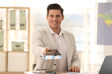 Photo of Travel agent with tickets and passports in office