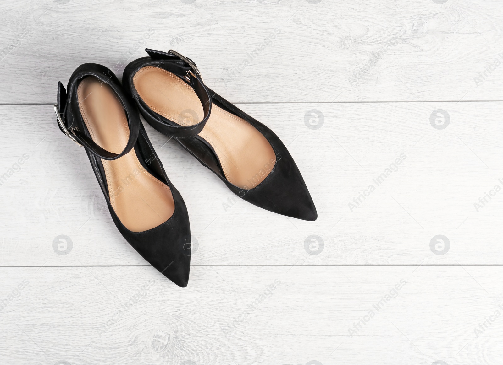 Photo of Pair of female shoes on wooden background, top view