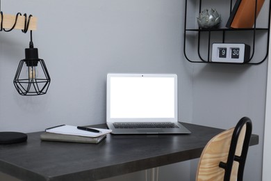 Photo of Comfortable workplace with modern laptop near light grey wall indoors. Space for design