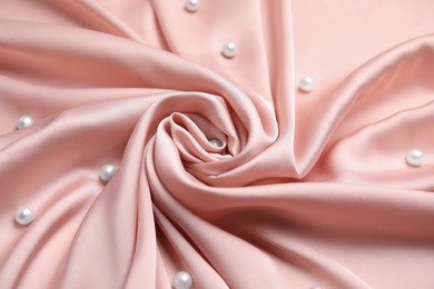 Photo of Many beautiful pearls on delicate pink silk