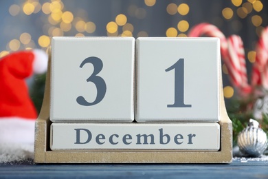 Wooden block calendar and Christmas decor on blue table. Holiday countdown