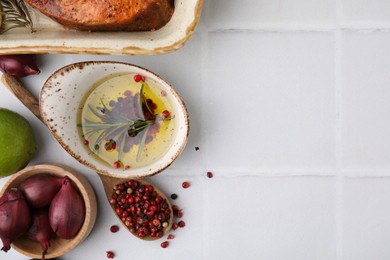 Fresh marinade, cooked fish and other products on white tiled table, flat lay. Space for text