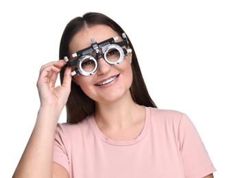 Vision testing. Young woman with trial frame on white background