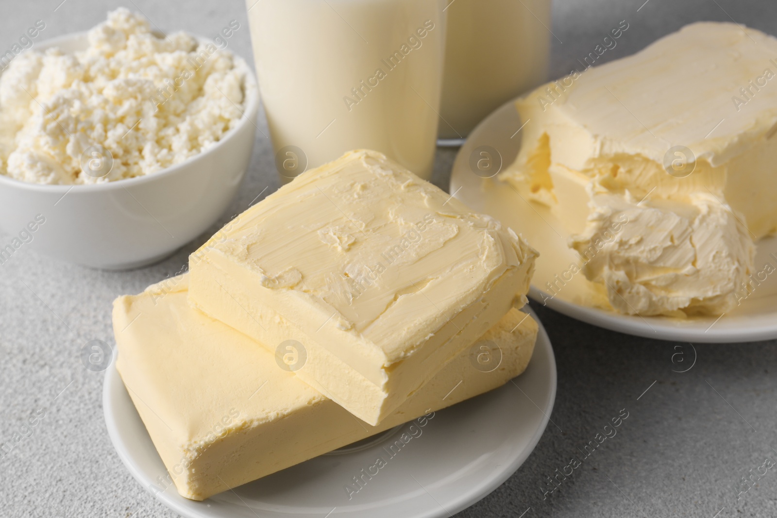 Photo of Tasty homemade butter and dairy products on white textured table, closeup