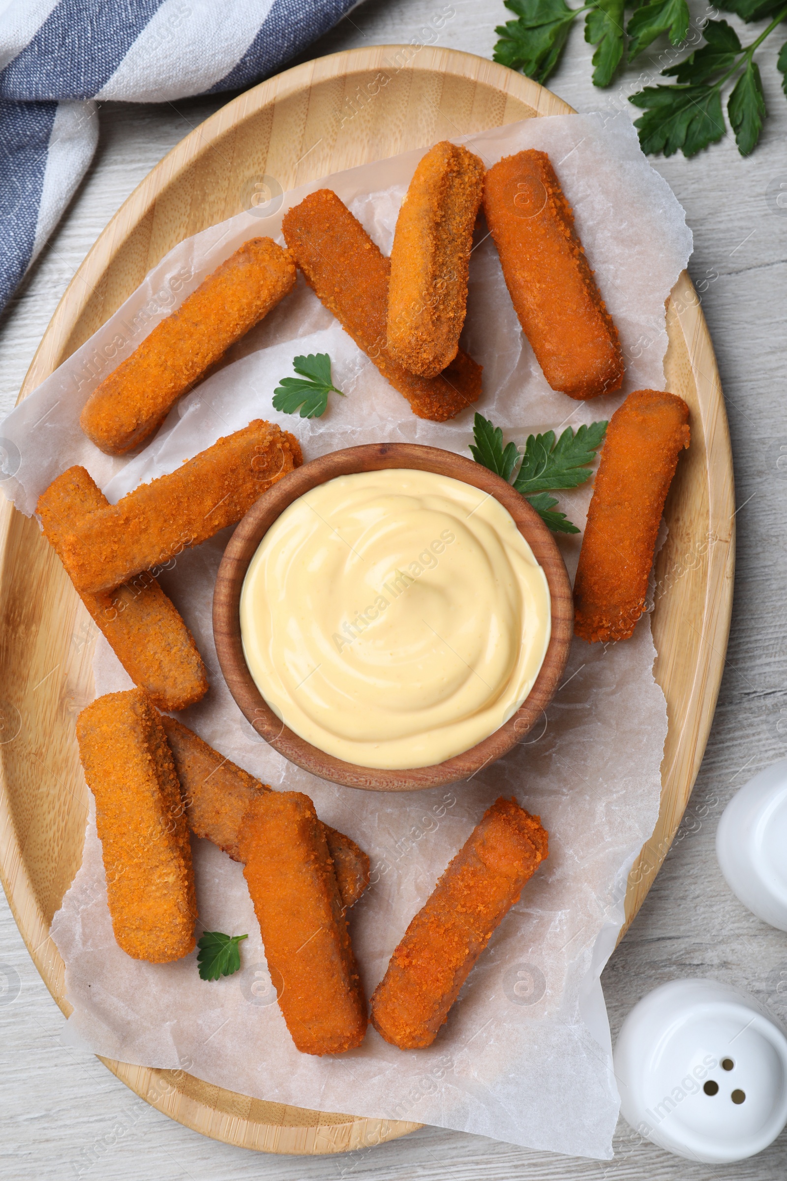 Photo of Delicious chicken nuggets and cheese sauce with parsley on white wooden table, flat lay