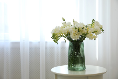 Beautiful bouquet with fresh freesia flowers on table indoors. Space for text