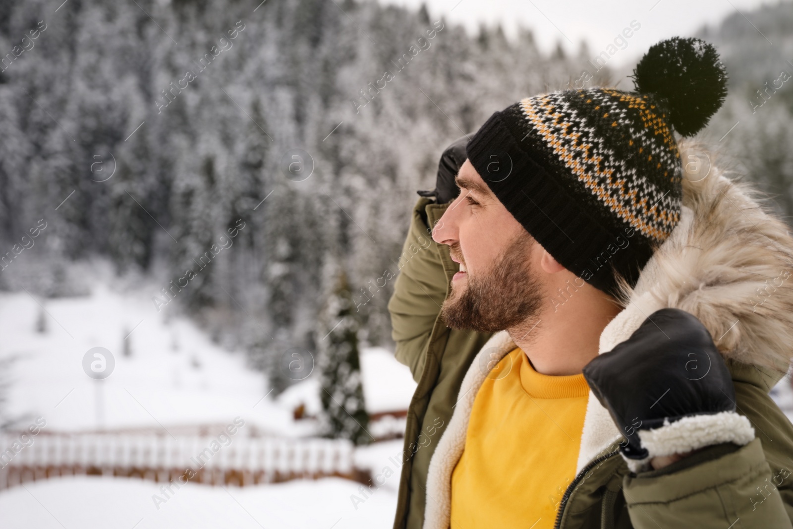 Photo of Happy man in warm jacket at resort. Winter vacation