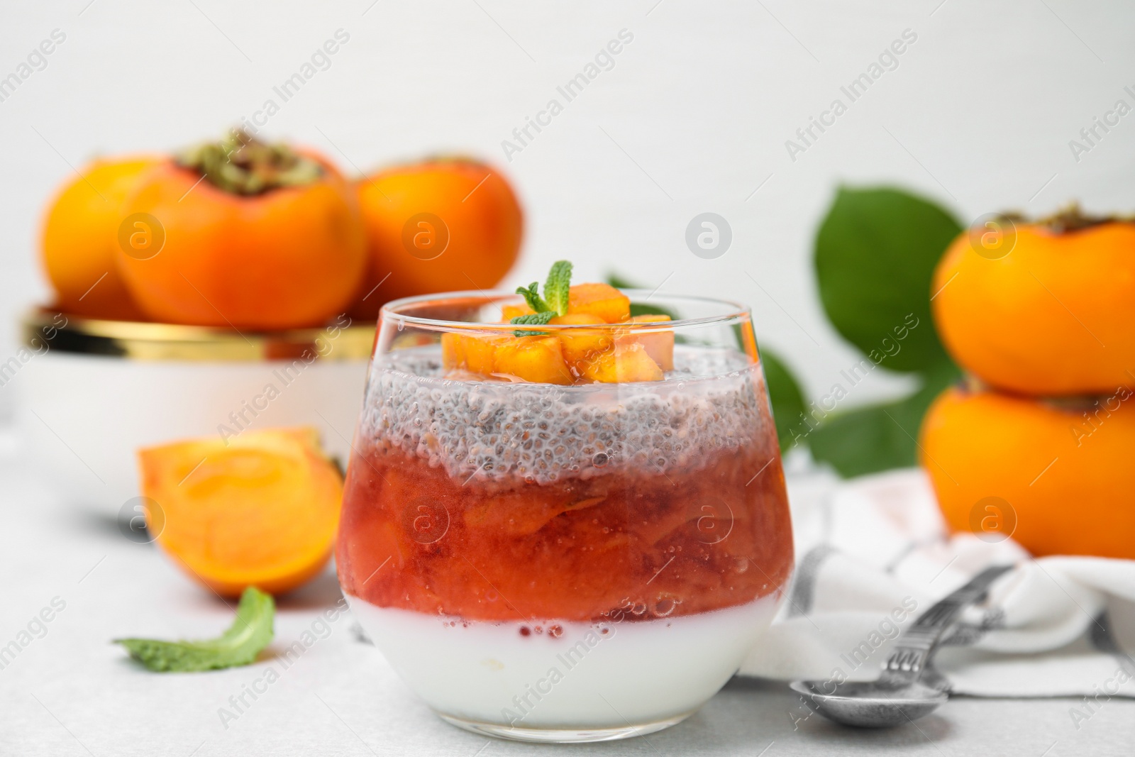 Photo of Delicious dessert with persimmon and chia seeds on table