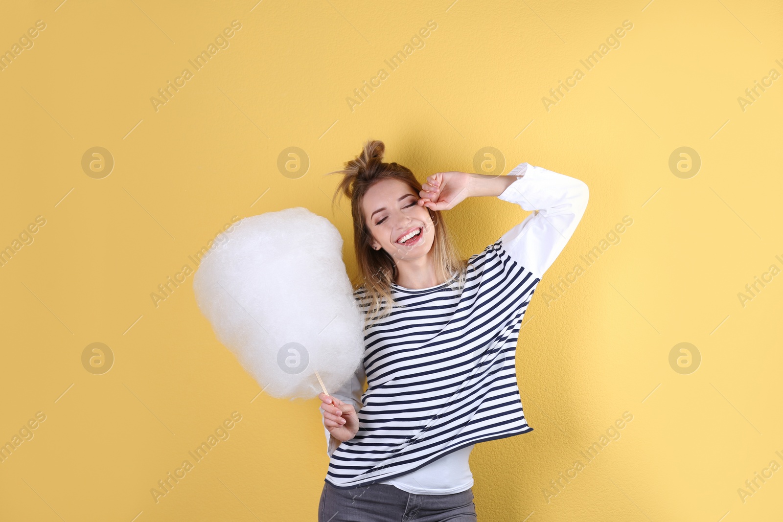 Photo of Young pretty woman with cotton candy on colorful background