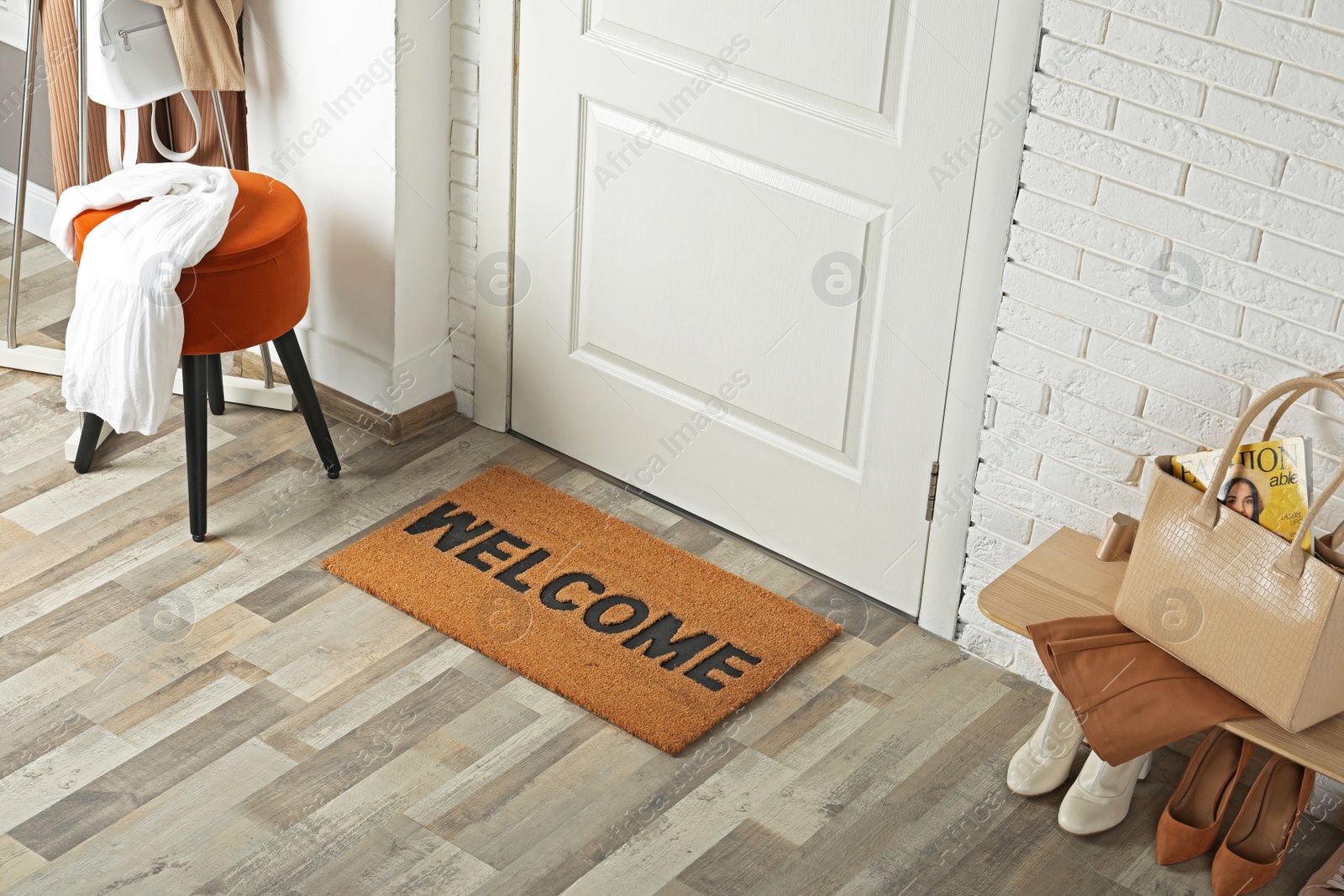 Photo of Doormat with word Welcome on wooden floor in hall