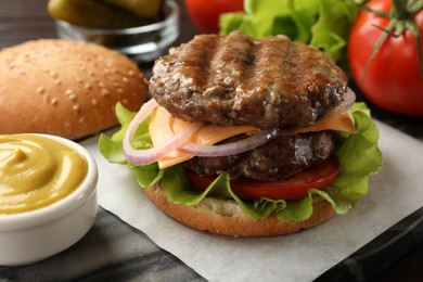 Tasty hamburger with patties, cheese and vegetables on board, closeup