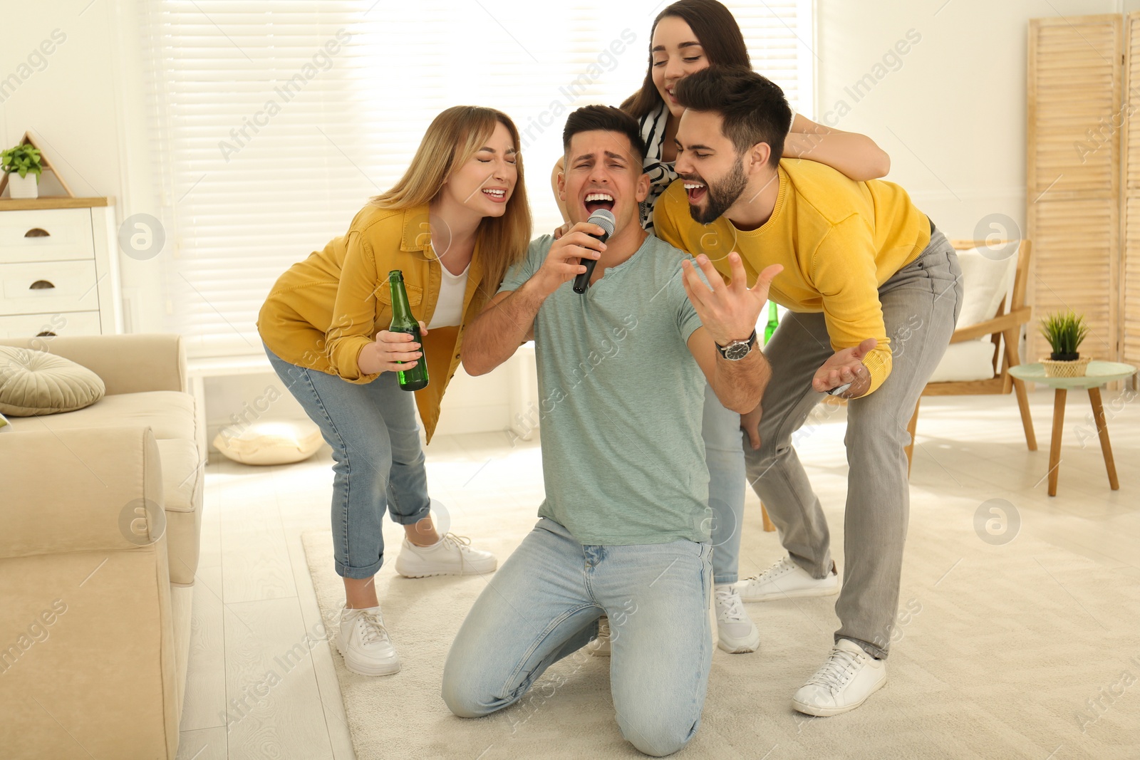 Photo of Happy friends singing karaoke together at home