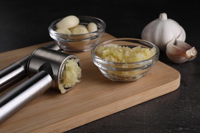 Photo of Garlic press and mince on grey table, closeup