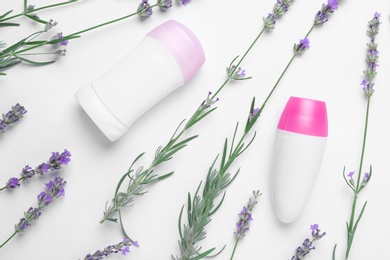 Different deodorants and lavender flowers on white background, top view