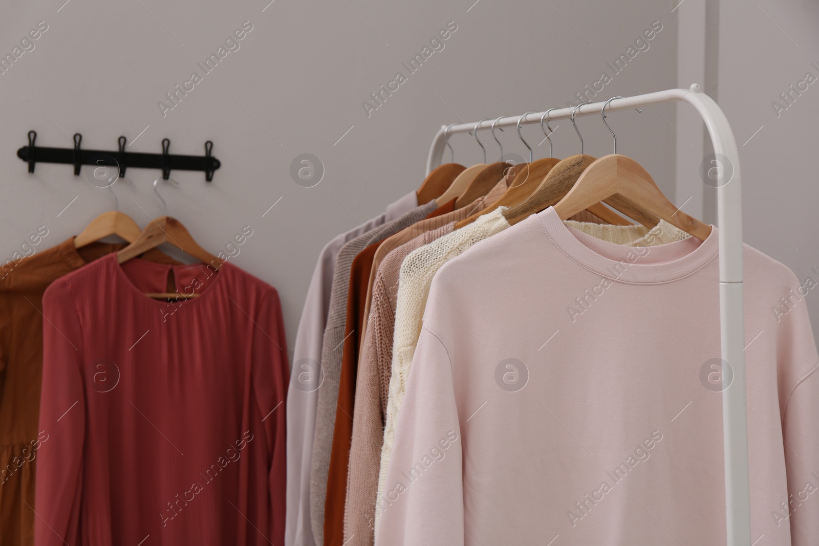 Photo of Rack with different stylish clothes near grey wall indoors