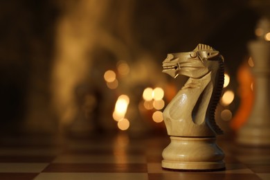 Wooden knight on chessboard, selective focus. Space for text